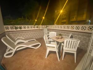 a table and chairs on a balcony at night at Casita Helena in Torrox +2 photos
