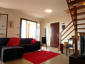 a living room with a black couch and a red rug at Arcobaleno Dante in Arizzano +5 photos