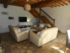 a living room with two couches and a tv at Gîte La Part des Anges in Saint-Angel