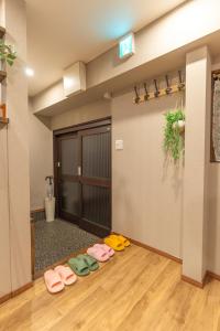 大阪Guest House Kubo Homes Tengachaya 1的地板上有一排鞋的房间
