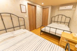 מיטה או מיטות בחדר ב-Guest House Kubo Homes Tengachaya 1