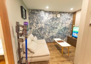 大阪Guest House Kubo Homes Tengachaya 1的客厅里有一张白色沙发和一台电视