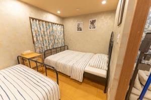 מיטה או מיטות בחדר ב-Guest House Kubo Homes Tengachaya 1