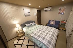 大阪Guest House Kubo Homes Tengachaya 1的一间小卧室,配有一张床和一张蓝色椅子