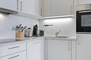 a kitchen with white cabinets and a sink at Hafenlodge - Urlaub im Denkmal in Wismar +10 photos
