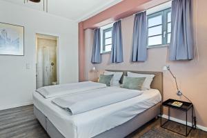 a bedroom with two beds and blue windows at Hafenlodge - Urlaub im Denkmal in Wismar