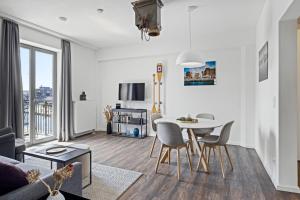 a white living room with a table and chairs at Hafenlodge - Urlaub im Denkmal in Wismar