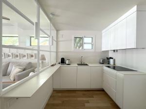 une cuisine blanche avec des armoires blanches et un évier dans l'établissement La Buganvilla, à Chiclana de la Frontera