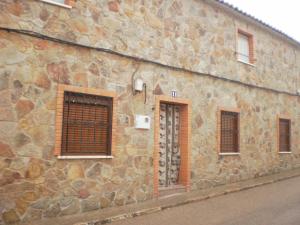a stone building with windows and a door at La Casita De ENRIQUETA in Belmonte