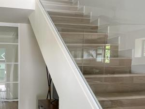 un escalier dans une maison avec une paroi en verre dans l'établissement La Buganvilla, à Chiclana de la Frontera