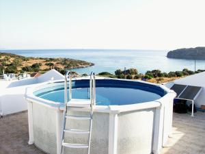 a hot tub with a ladder next to the ocean at Vrokastro Apartments in Istro