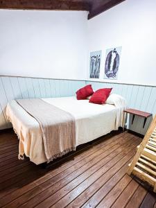 a bedroom with a bed with red pillows on it at Namaste Flats Praia do Rosa in Imbituba