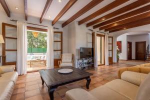 een woonkamer met een bank en een tafel bij Villa Martina in Can Picafort