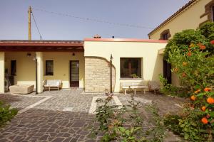 a patio of a house with chairs and flowers at Casa di Nonna Rosa e Nonno Ciccito in Masullas