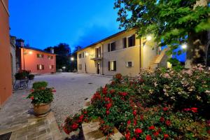 a building with flowers in a courtyard at night at Casa Vacanze Residenza Bocci in Foligno
