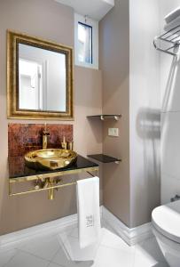 a bathroom with a gold sink and a mirror at Nuru Ziya Residences in Istanbul