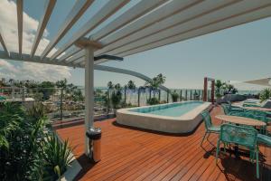 a deck with a pool and a table and chairs at Yacht by Hosppedar in João Pessoa