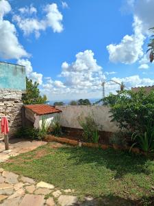 una casa con un muro di pietra accanto a un cortile di Casa Nova Terra a São Thomé das Letras