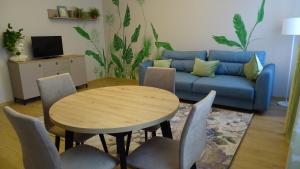 Una sala de estar con una mesa y un sofá azul. en Apartment on Brivzemnieka, en Liepāja