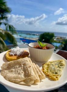 a plate of food with eggs and a bowl of food at Ukulhas Sands in Ukulhas