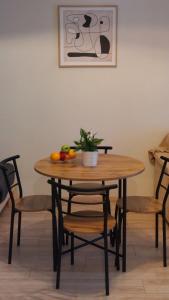 a wooden table with chairs and a bowl of fruit on it at Miranda's Apartment Koukaki in Athens