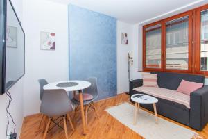 萨拉热窝Apartman Bene的客厅里有一张沙发和一张桌子。