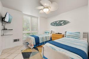 een slaapkamer met twee bedden en een plafondventilator bij D27 - Beachside Bungalow in Oceanside +51 foto's