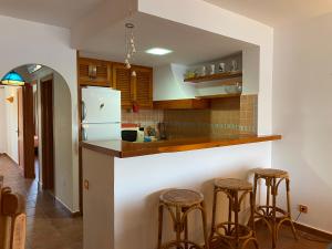 a kitchen with a counter and some stools at CARACOLA by SOM Menorca in Fornells