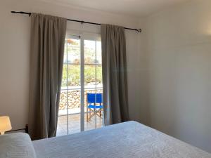 a bedroom with a bed and a sliding glass door at CARACOLA by SOM Menorca in Fornells