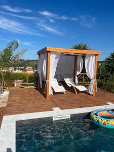 a gazebo and chairs next to a swimming pool at KABACEIRA VILLAGE in Atalaia