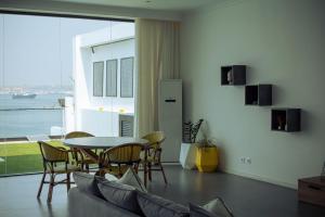 ルアンダにあるSunrise Apartmentのテーブルと椅子のあるリビングルーム +15枚の写真