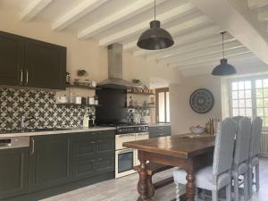a kitchen with a wooden table with chairs and a stove at Magical Mellecey in Mellecey