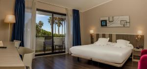 Habitación de hotel con cama blanca y balcón en Hotel La Palma de Llanes, en Llanes