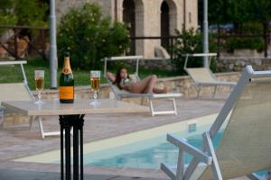 福利尼奧的住宿－博奇卡薩瓦卡澤酒店，游泳池畔的桌子上放着一瓶香槟和两杯酒