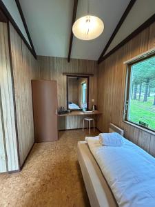 una camera con letto e scrivania di Arhus Cottage and Camping a Hella