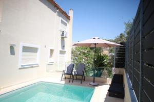 ラゴニッシにあるLuxury Villa with Pool in Athens Rivieraの椅子2脚と傘が備わったプール