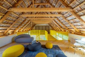 an attic room with yellow and blue chairs and a laptop at Porumbacu 216 in Porumbacu de Sus