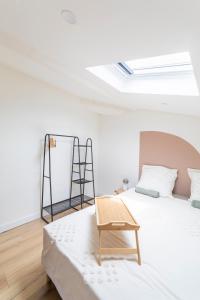une chambre blanche avec un lit et une chaise dans l'établissement Le Belvédère Nîmois proche centre ville Clim &Véranda MaisonCarréeConciergerie, à Nîmes
