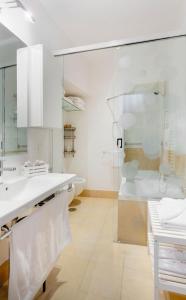 a bathroom with white counters and a glass shower at L'obelisque maison de luxe in Rome