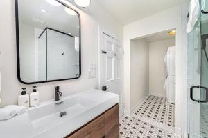 a white bathroom with a sink and a mirror at The Marigold - Gorgeously remodelled PEC farmhouse in West Lake