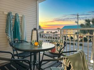 a table and chairs on a balcony with a view of the ocean at Sunrise Destin-ation Beach view Heated Pool in Destin