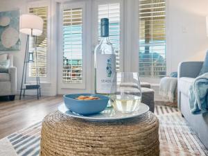 a bottle of wine and a bowl of food on a table at Sunrise Destin-ation Beach view Heated Pool in Destin +42 photos