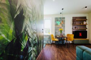 a dining room with a table and yellow chairs at Jungle Apartment chill&bed Zator in Zator