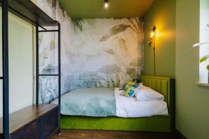 a bedroom with a bed with a painting on the wall at Jungle Apartment chill&bed Zator in Zator