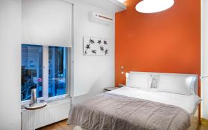 a bedroom with an orange wall and a bed and a window at Nuru Ziya Residences in Istanbul