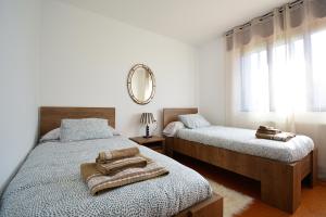 a bedroom with two beds and a mirror on the wall at Casa frente al mar en A Illa de Arousa in Isla de Arosa