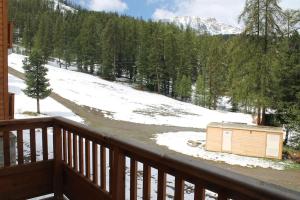 a small wooden box on a balcony with a snow covered field at appartement 5 places à VARS in Vars