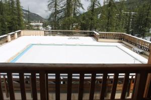 a swimming pool on a deck with snow on the ground at appartement 5 places à VARS in Vars
