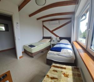 two beds in a small room with a window at Monteurwohnung SEEBLICK AUSBLICK 16356 Werneuchen bei Berlin in Werneuchen