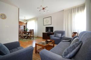 a living room with two blue couches and a table at Casa frente al mar en A Illa de Arousa in Isla de Arosa